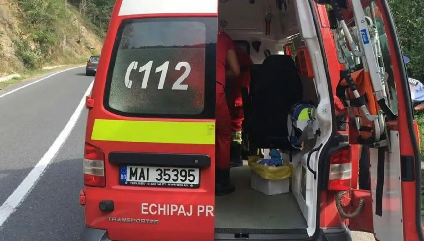 O autospecială roșie cu ușile din spate deschise este oprită pe șosea, iar o persoană îmbrăcată în negru se află în interior.