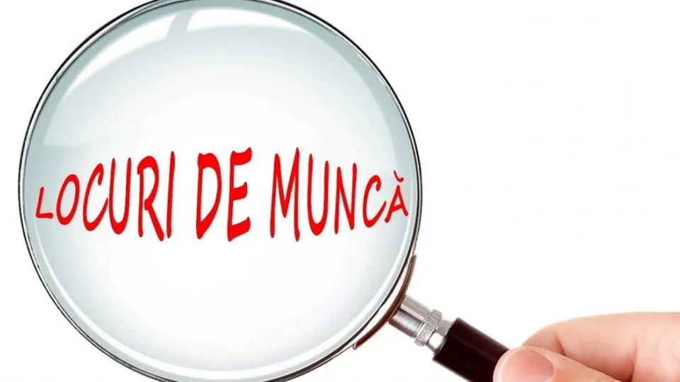 O lupă mărește textul roșu „LOCURI DE MUNCĂ”, iar o mână ține mânerul în partea dreaptă.