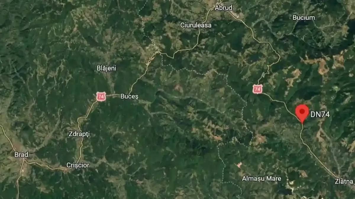 Imagine satelitară cu relief verde, drumuri și etichete de localități, cu un marcaj roșu lângă DN74.