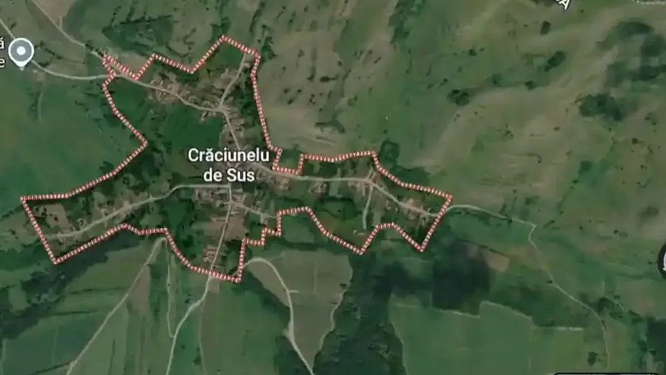 O imagine satelitară prezintă o așezare, terenuri verzi, drumuri și un contur punctat roșu, alături de o etichetă centrală.