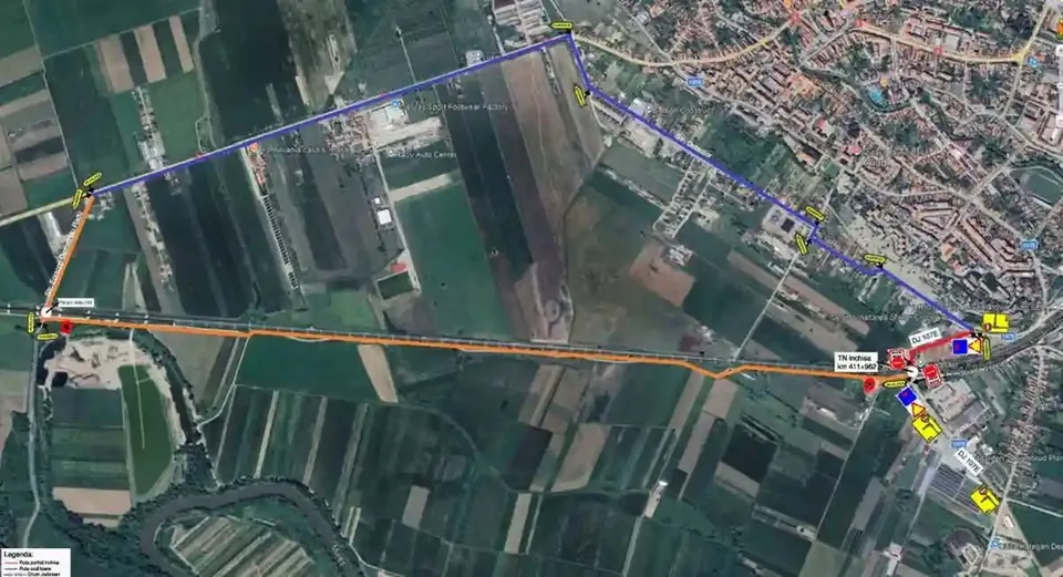 O imagine aeriană arată câmpuri, drumuri și clădiri, peste care sunt trasate linii albastre și portocalii și câteva marcaje colorate.