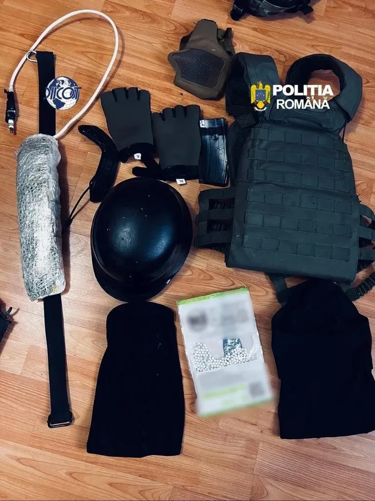Pe o podea de lemn sunt așezate o vestă inscripționată «POLIȚIA ROMÂNĂ», o cască neagră, mănuși, o bâtă și un document neclar.