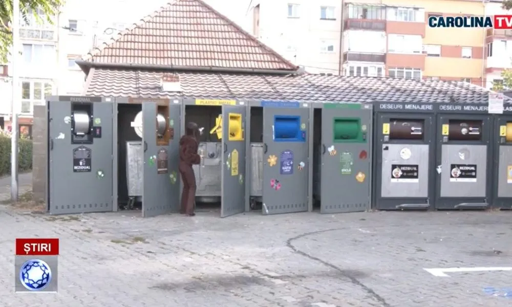 Un rând de containere cu compartimente colorate este amplasat pe o platformă pavată; o persoană în haine închise stă lângă un compartiment deschis.