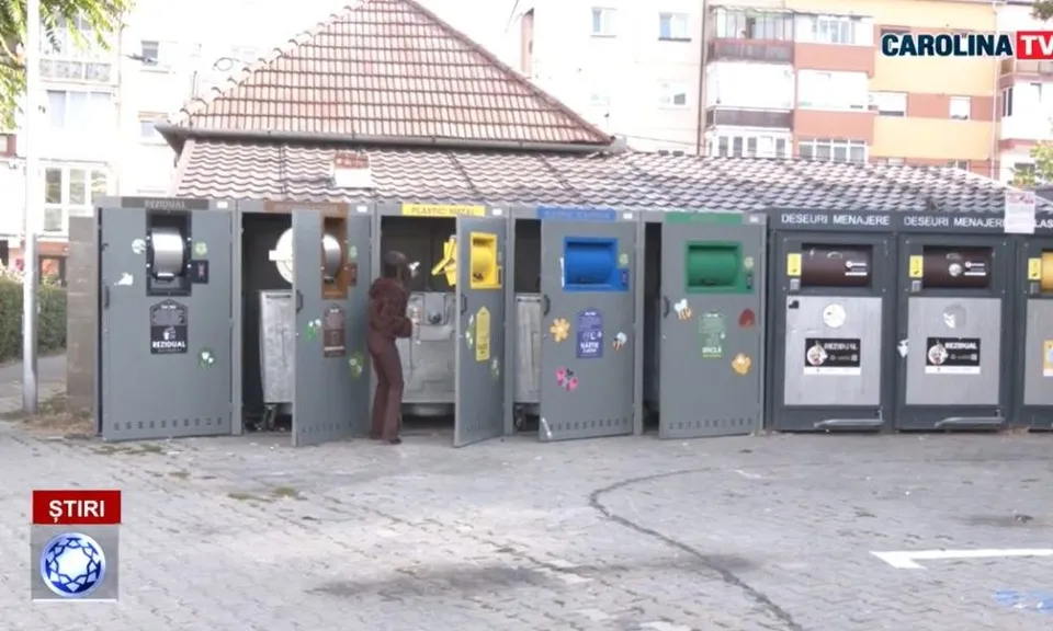 Un rând de containere cu compartimente colorate este amplasat pe o platformă pavată; o persoană în haine închise stă lângă un compartiment deschis.