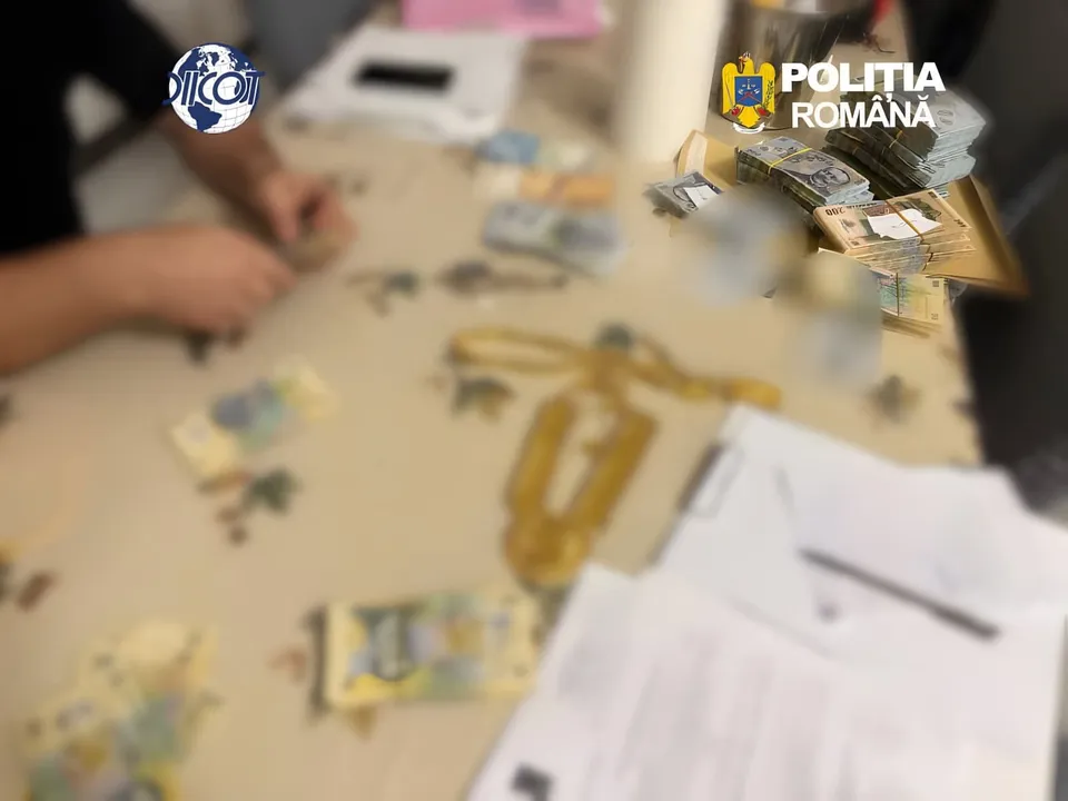 Pe o masă se văd bancnote, plicuri și foi tipărite; în stânga apar mâinile unei persoane, iar în colțurile de sus sunt sigle.