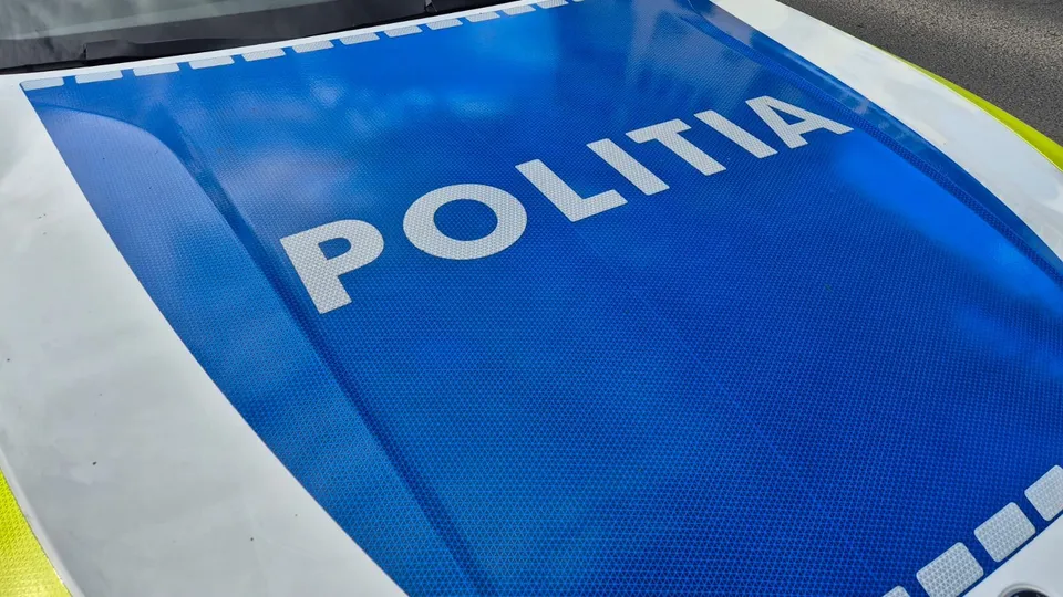 Pe o suprafață albastră, încadrată de margini albe și porțiuni galbene, apare inscripția albă „POLIȚIA”.