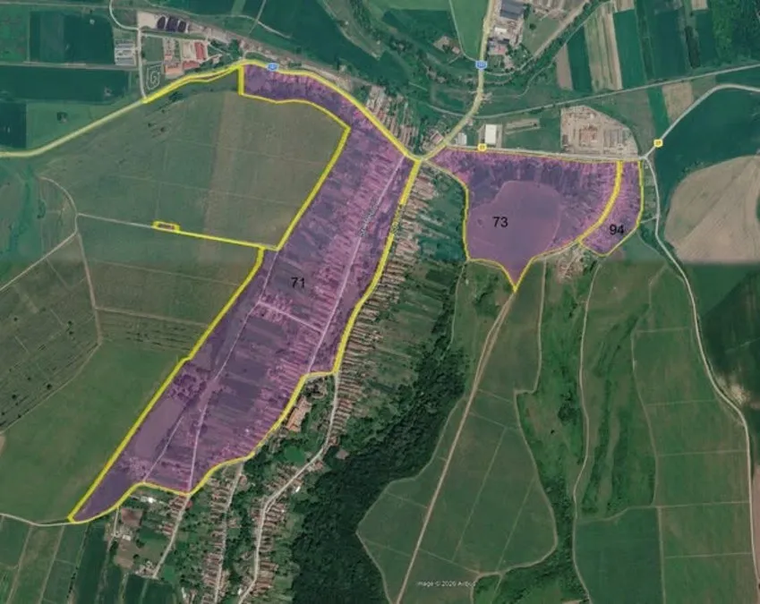 O imagine aeriană arată terenuri, drumuri și clădiri mici, cu mai multe suprafețe colorate în mov și delimitate cu linii galbene.